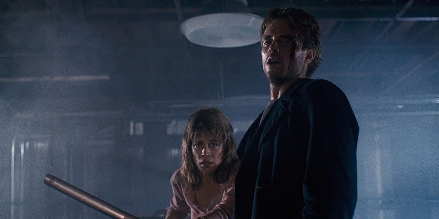 A bloodied Kyle Reese and Sarah Connor look on in a factory in THe Terminator.