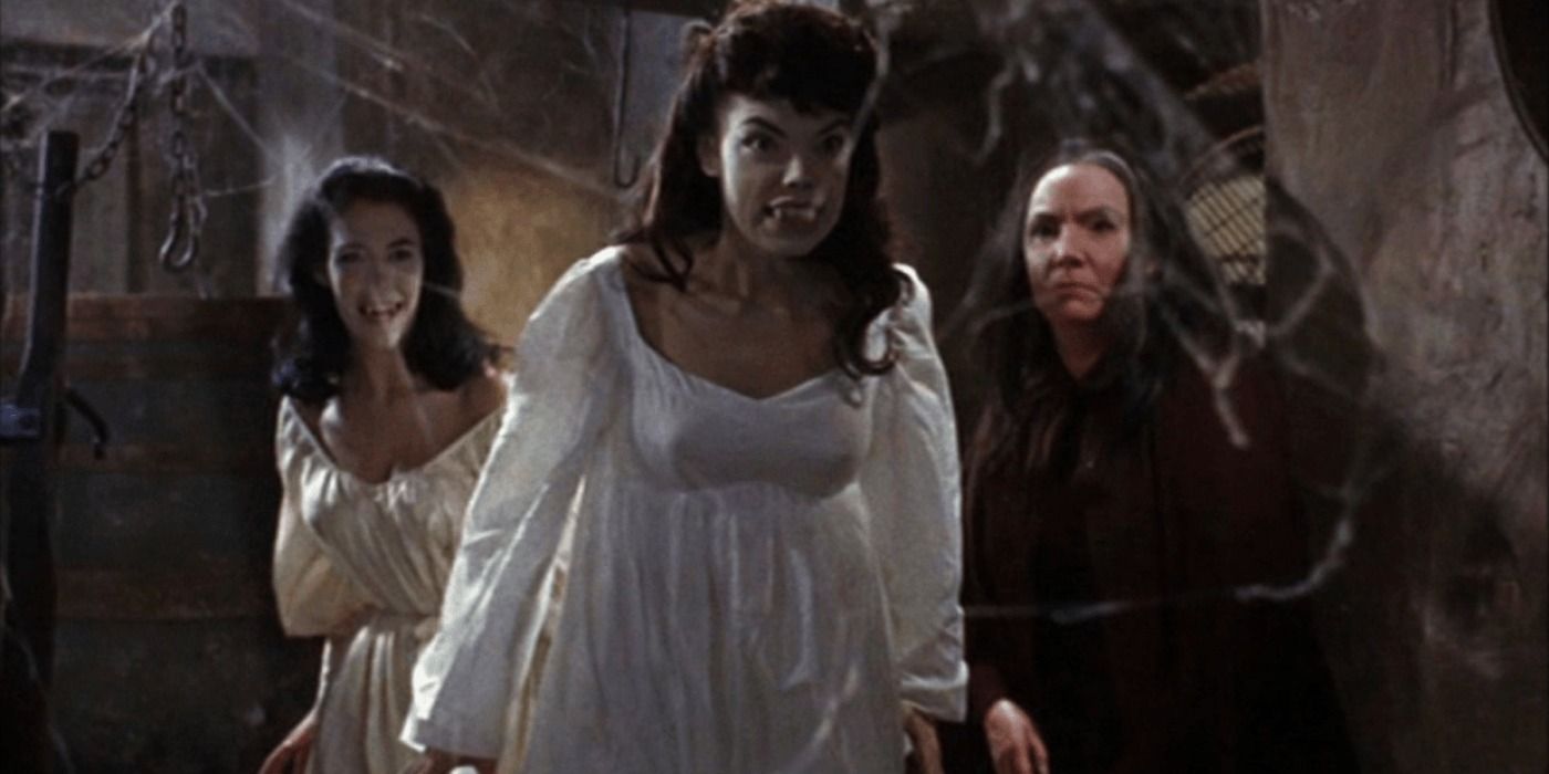 The Brides of Dracula walking through cobwebs.