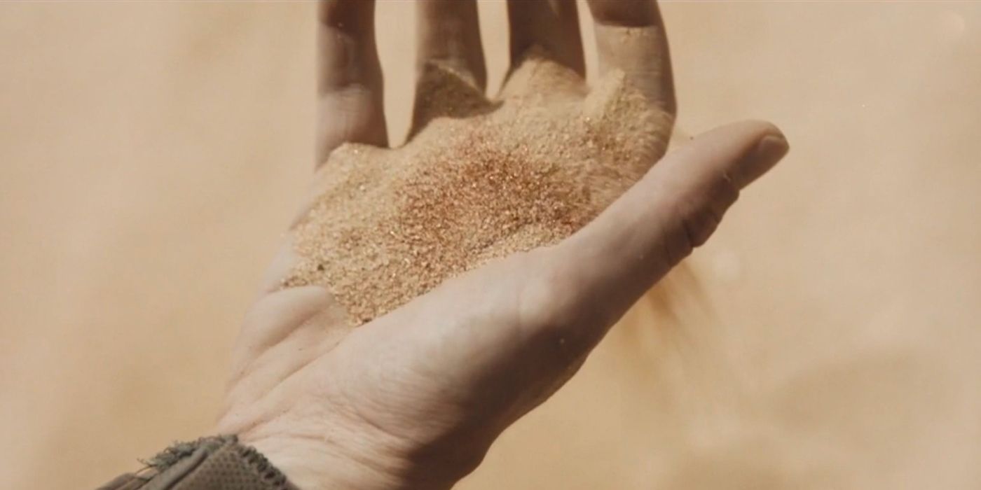 Paul holds a handful of spice in Dune (2021).