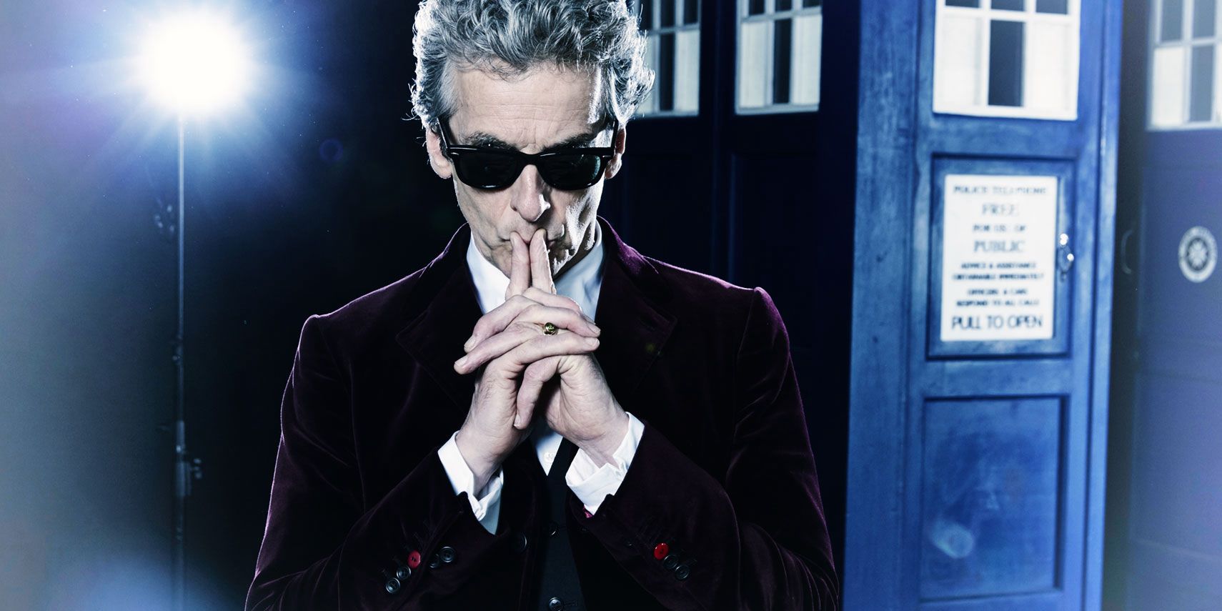 The Twelfth Doctor strikes a thinking pose in front of the TARDIS.