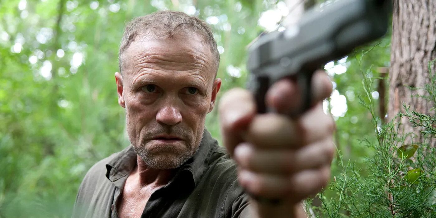 Merle aims a gun at someone in The Walking Dead.