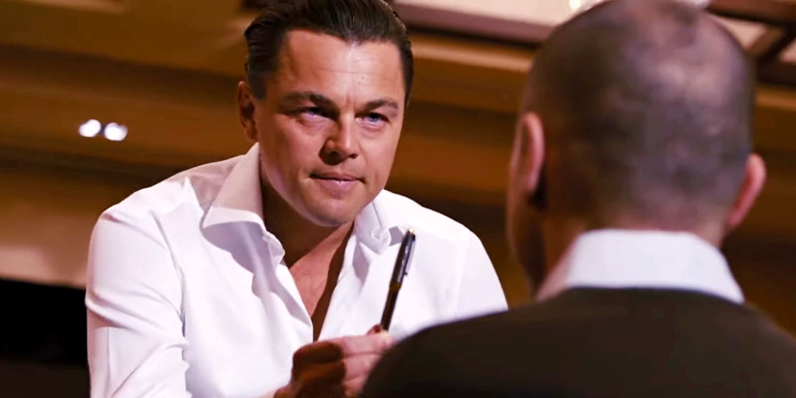 Jordan segurando uma caneta em um seminário em O Lobo de Wall Street