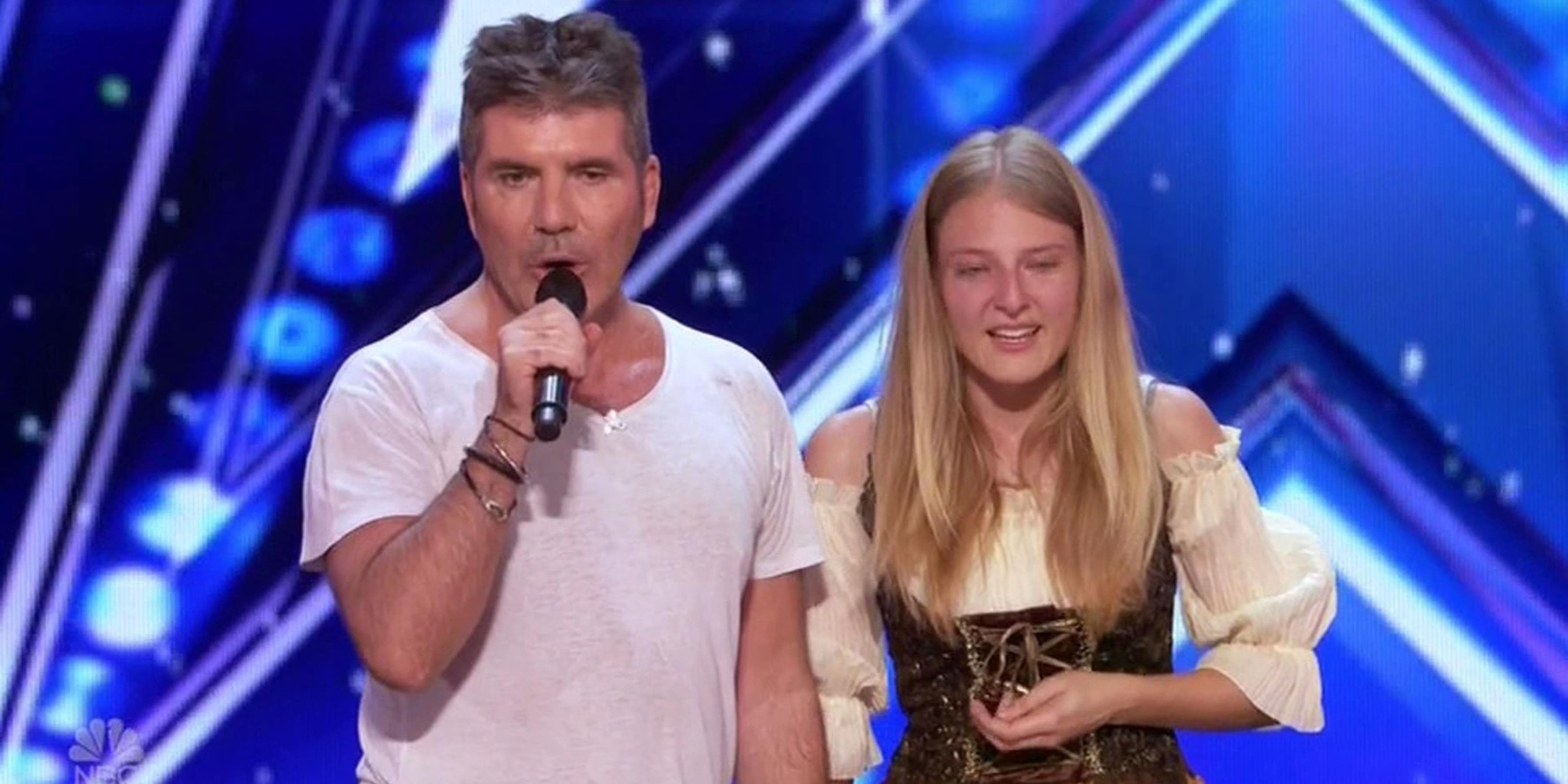 Simon Cowell in a white tee standing next to Sara on BGT