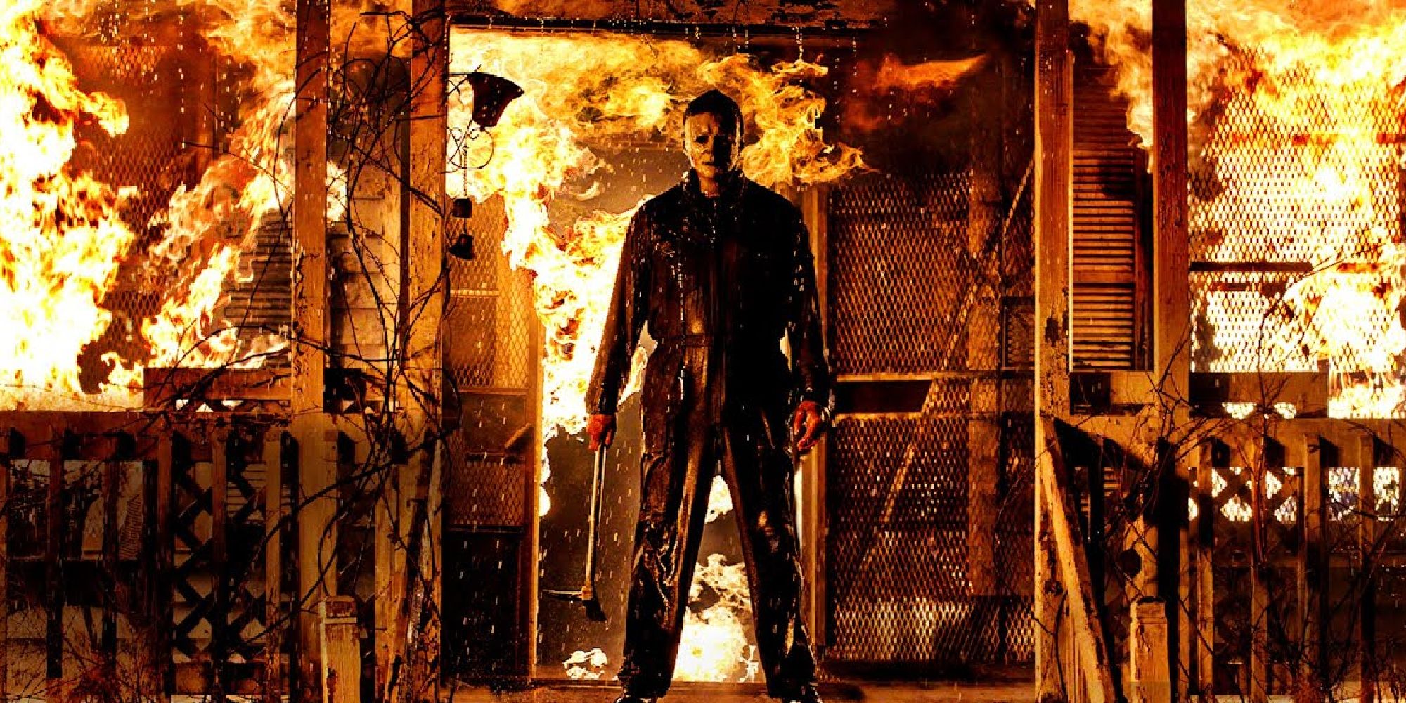 Michael Myers stands in front of a burning house in Halloween Kills