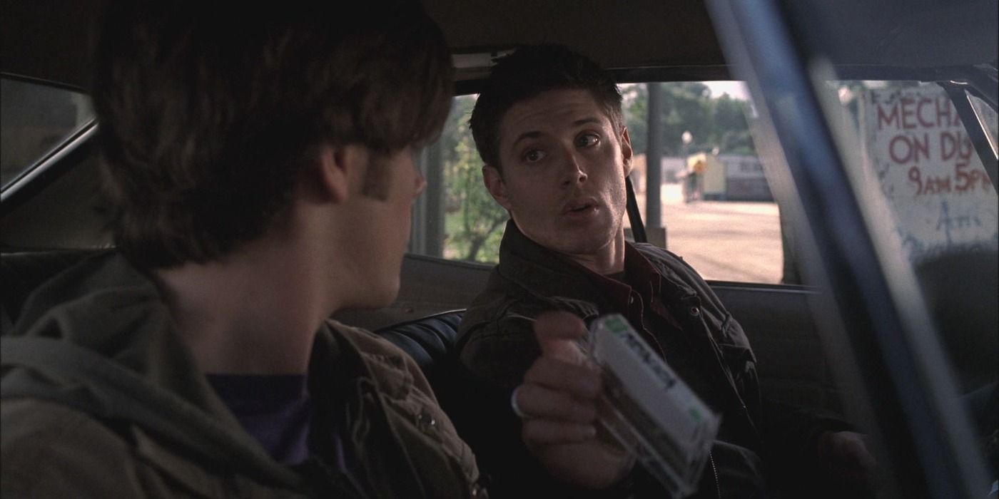 Dean holding a cassette in Supernatural looking at Sam