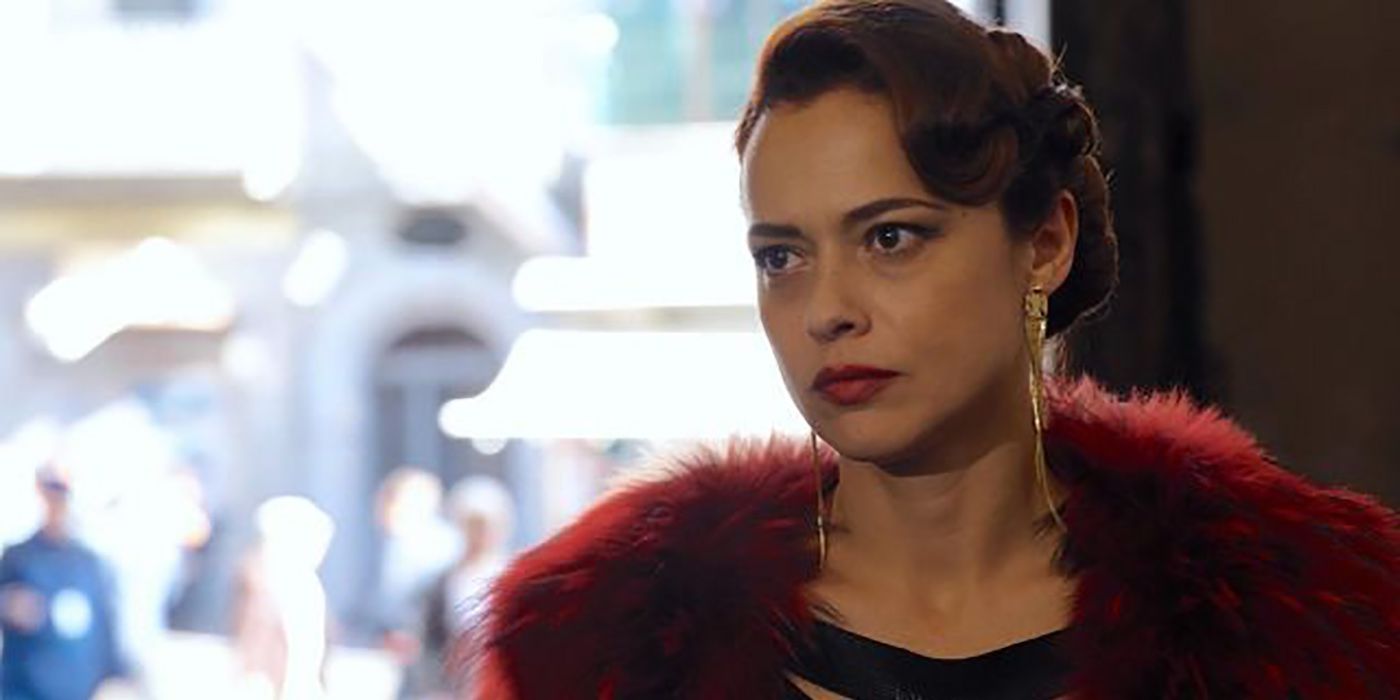 Lila Facchini from Sense8, looking at someone, wearing red fur.