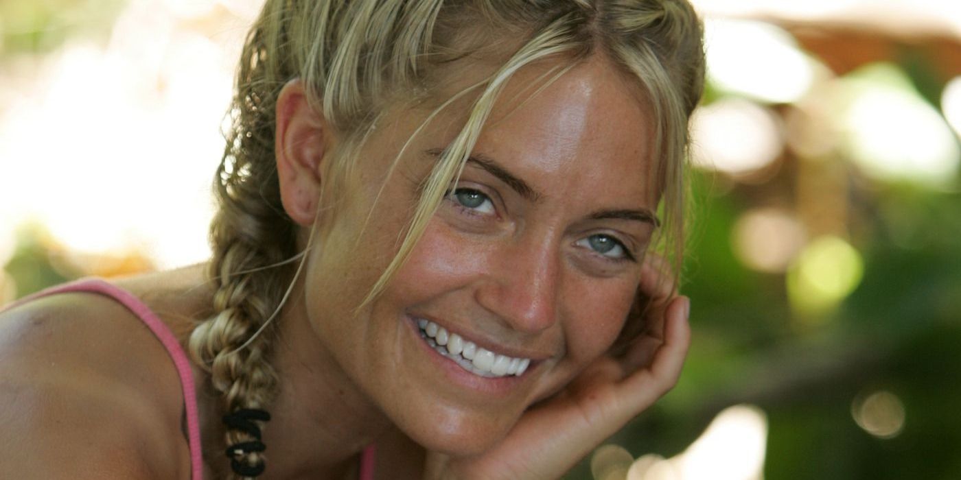 Jenn Lyon sonríe mientras se sienta a la sombra en el campamento de su tribu en Survivor: Palau.