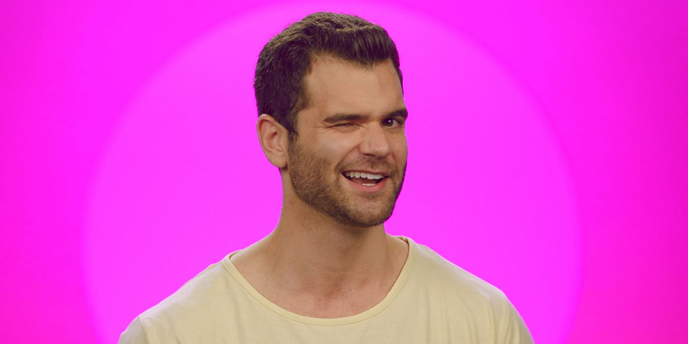 A headshot of Nick from The Circle season 3, winking with a bright pink background.