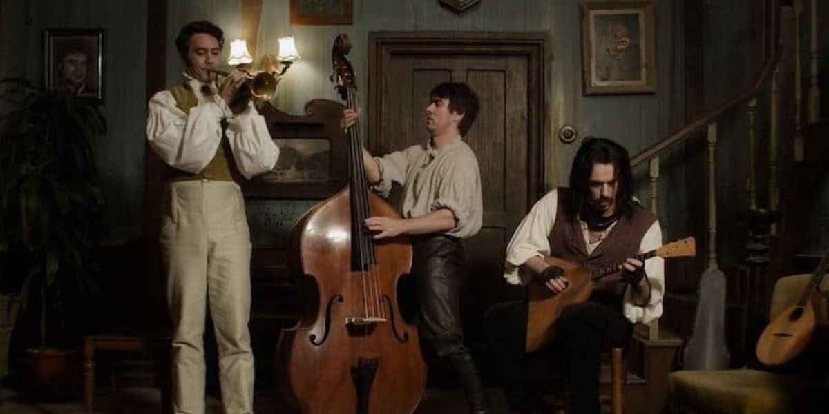 the main vampires of What We Do In The Shadows playing instruments together