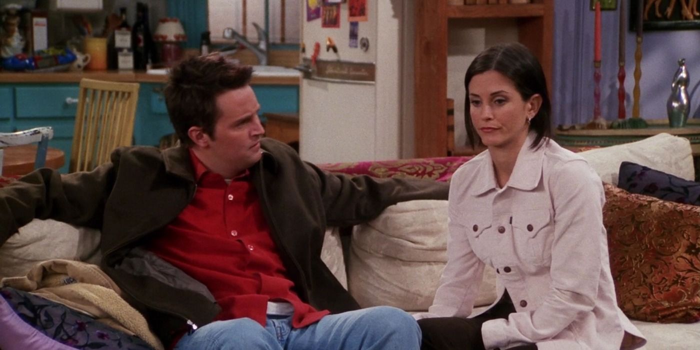 A sad-looking Monica sitting next to Chandler on a couch in Friends