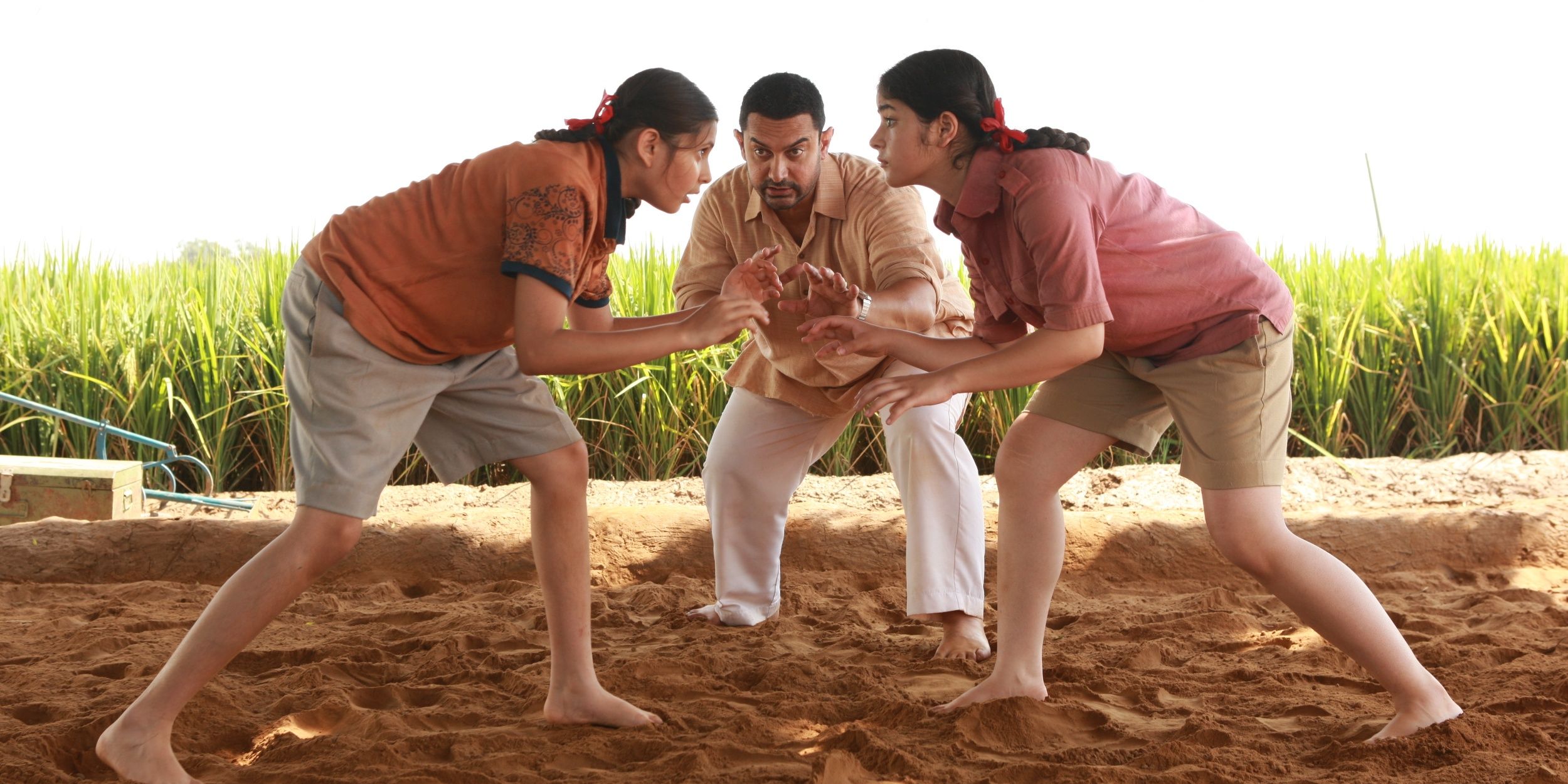 Aamir Khan as Phogat with his two on-screen daughters in Dangal