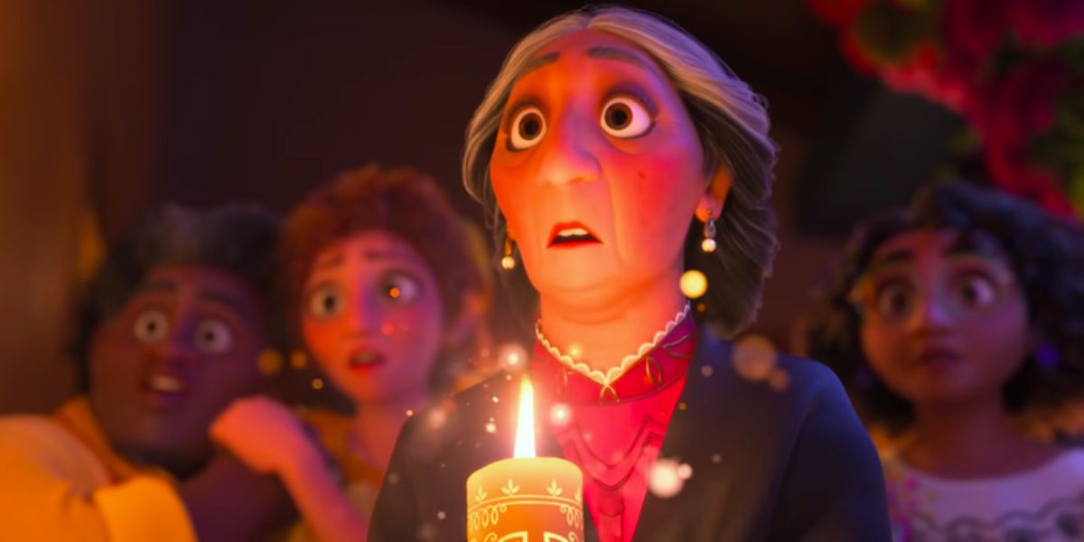 Abuela looks shocked while holding a candle in Disney's Encanto.