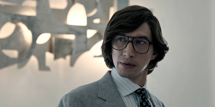 Maurizio Gucci wearing glasses and looking to his side in House of Gucci.