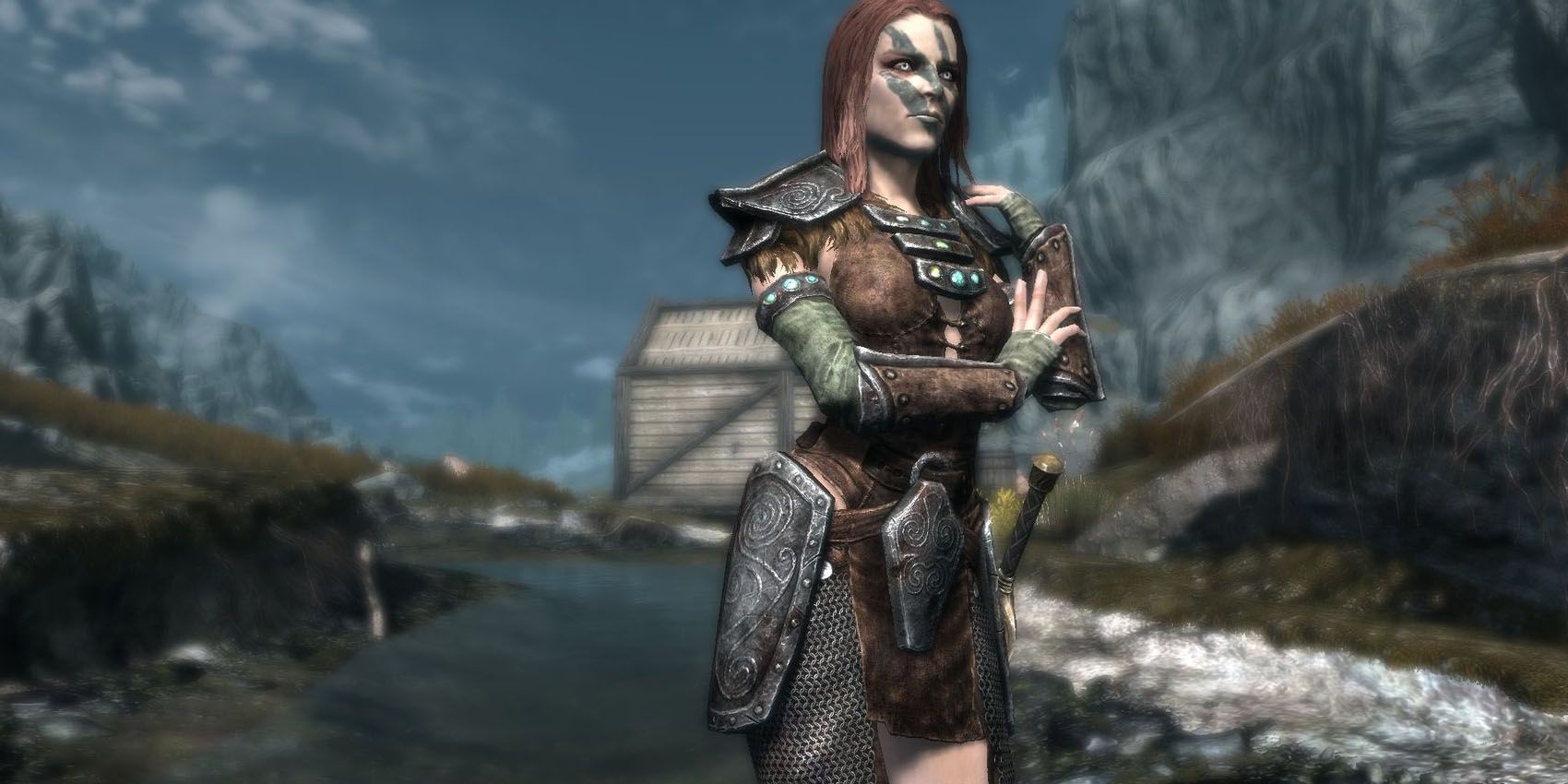 Aela the Huntress stands in a river in Skyrim.