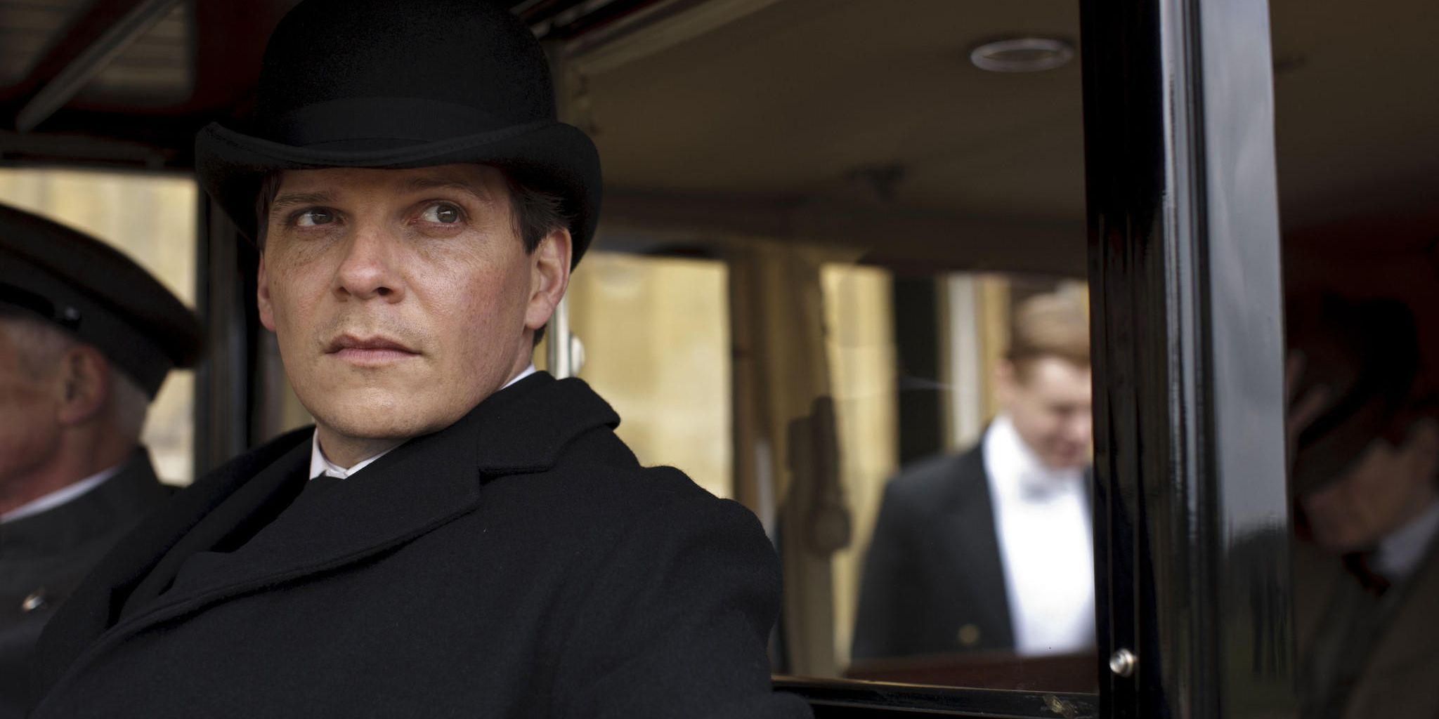 Alex looks out of a car in Downton Abbey.