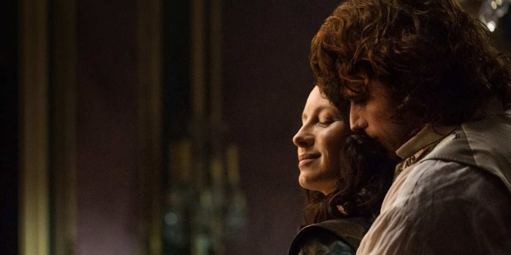 An image of Claire and Jamie hugging in the parlor in Outlander