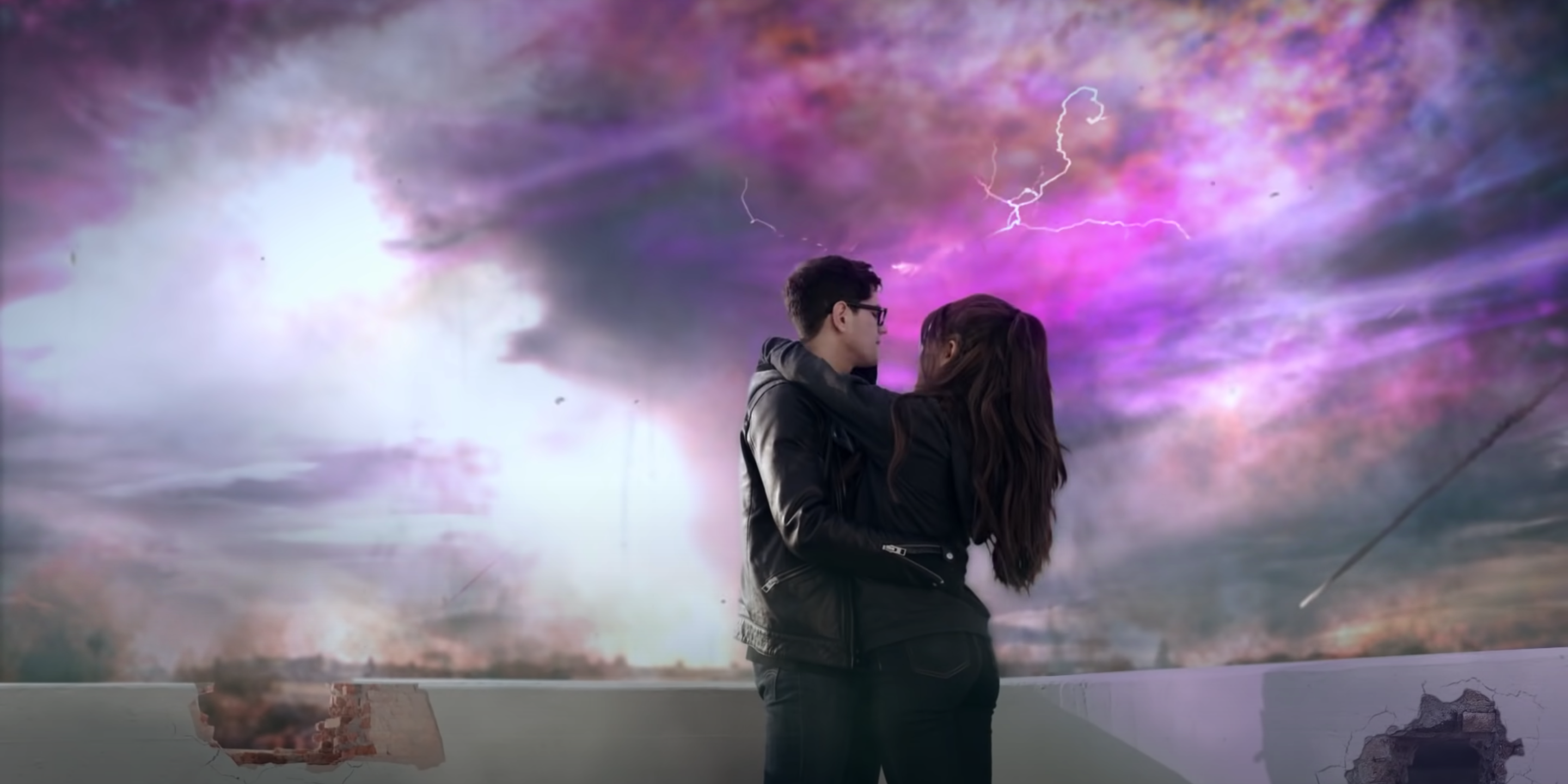 Image of Ariana Grade embracing a boy in front of a purple lightning storm in the video for One Last Time.