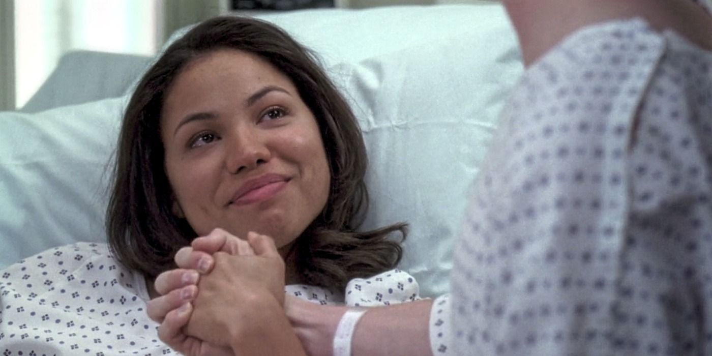 Beth Munroe in a hospital bed smiling and holding someone&rsquo;s hand in Grey&rsquo;s Anatomy