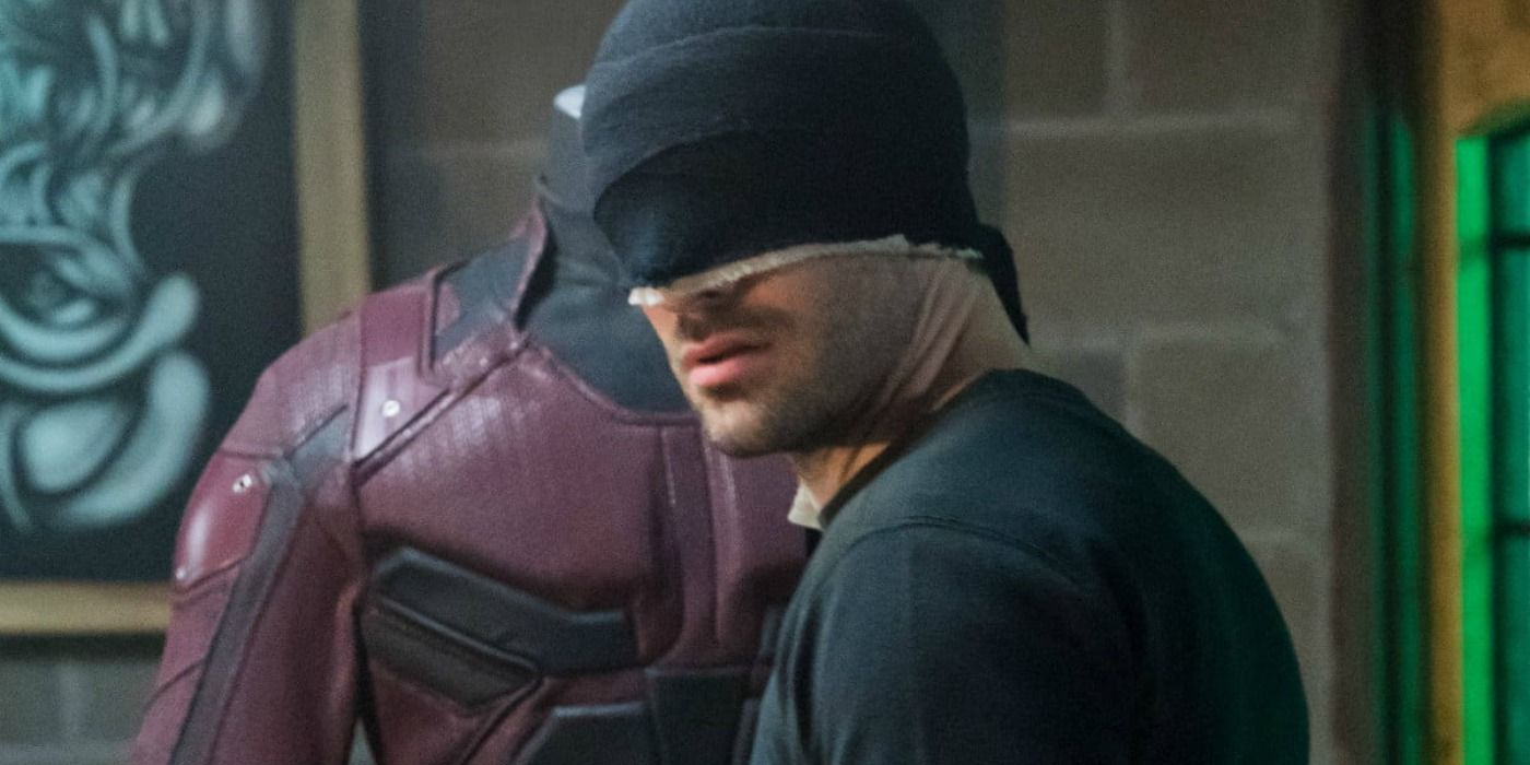 Daredevil wearing the makeshift black suit during season 3 in front of a replica red suit