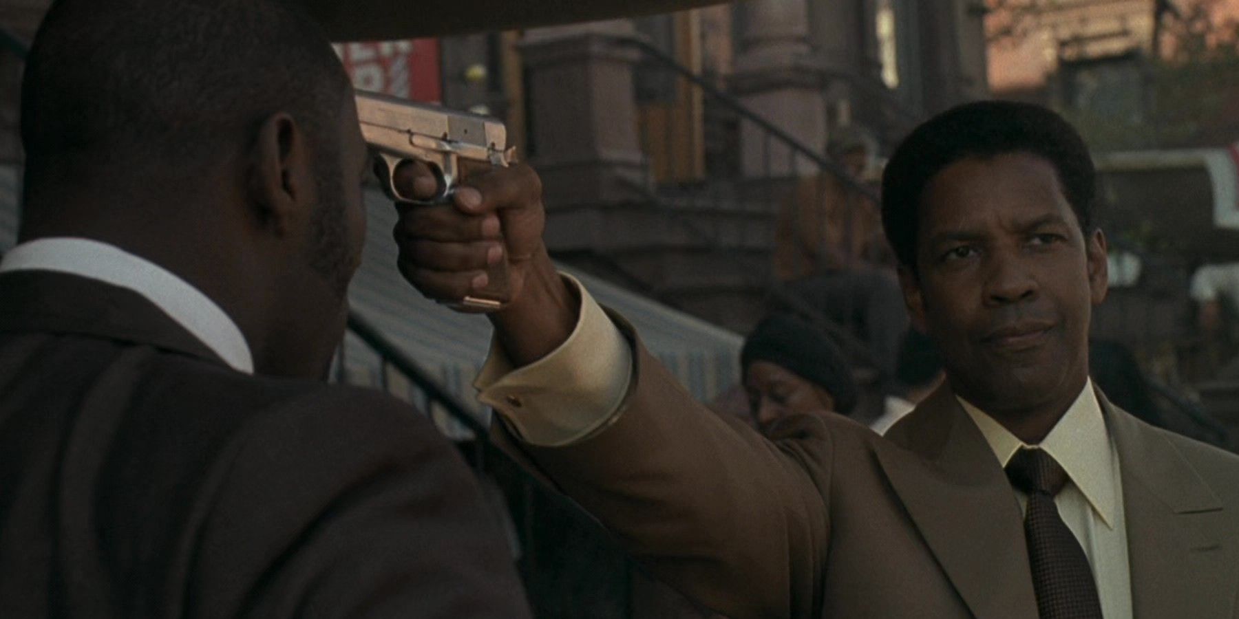Denzel Washington aims a gun at Idris Elba in American Gangster