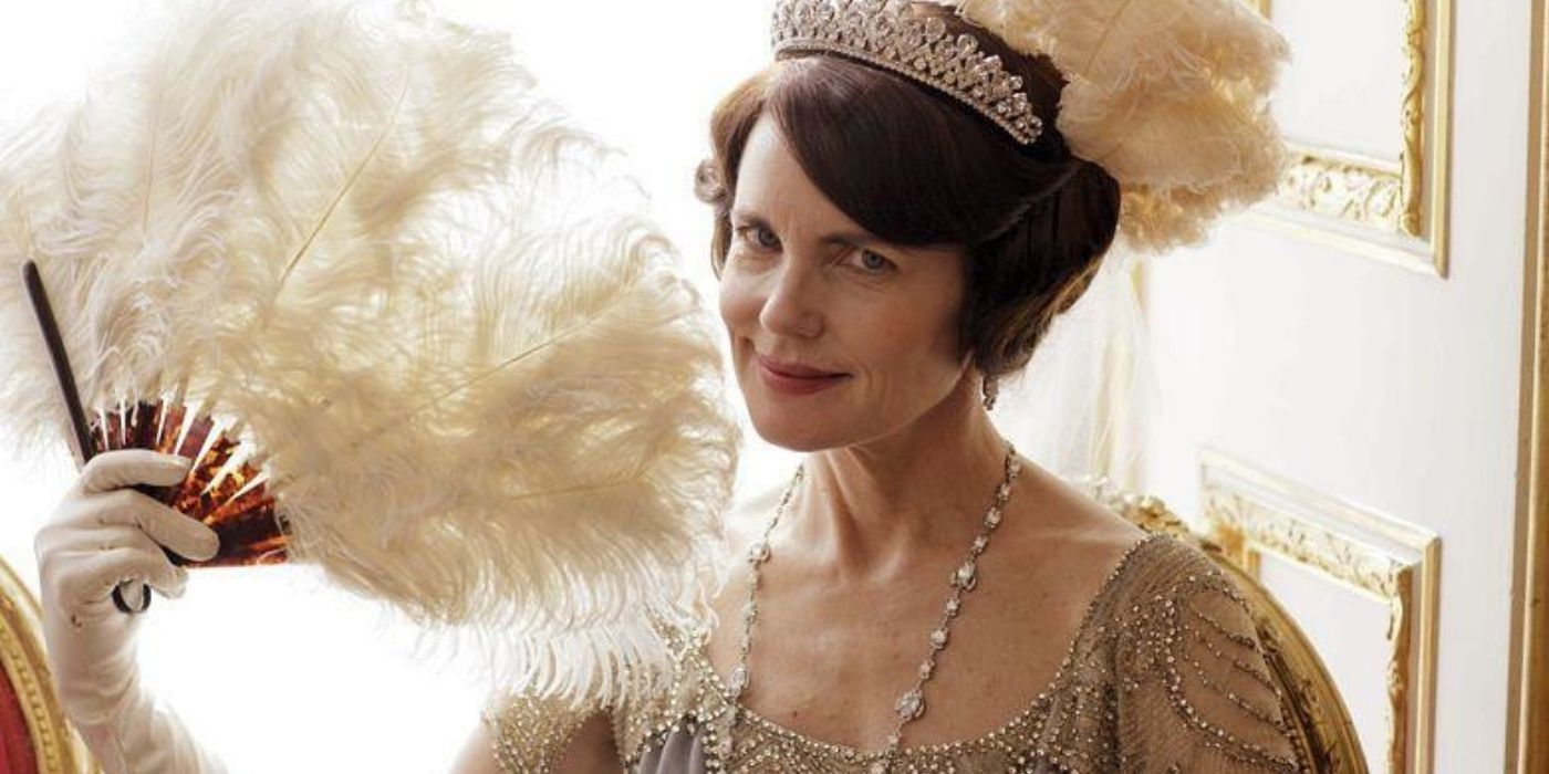 Cora Crawley smiling while holding a fan in Downton Abbey