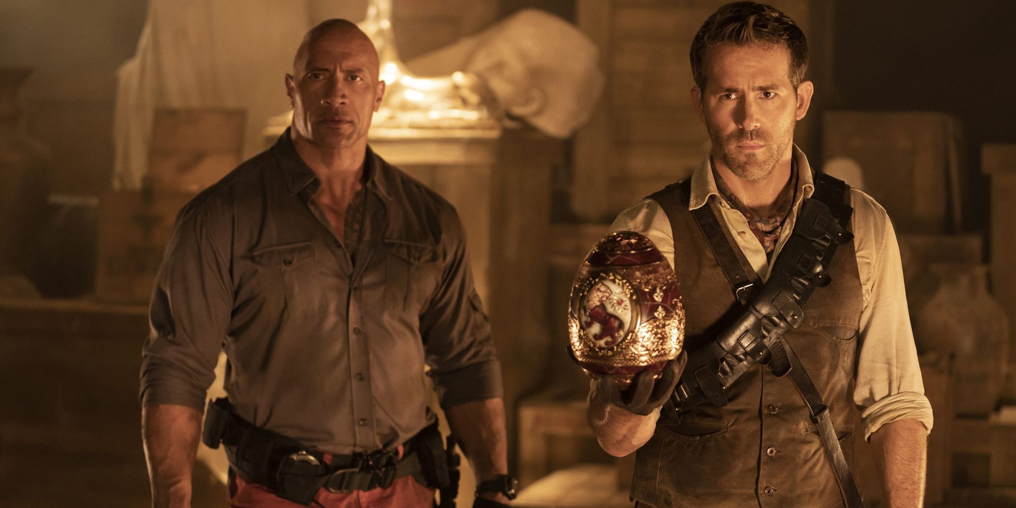Dwayne The Rock Johnson as John Hartley and Ryan Reynolds as Nolan Booth Holding the Cleopatra Egg in Red Notice