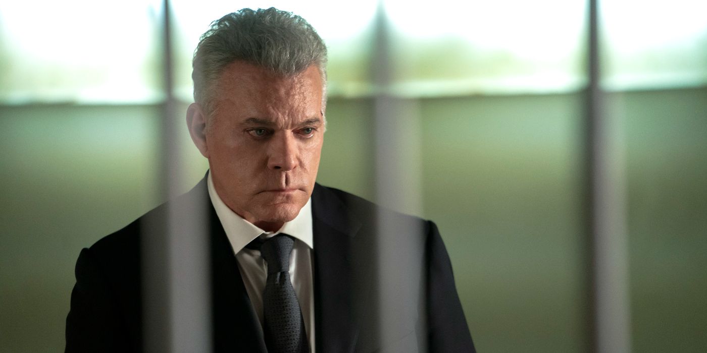 Ray Liotta looks on sternly while framed through bars 