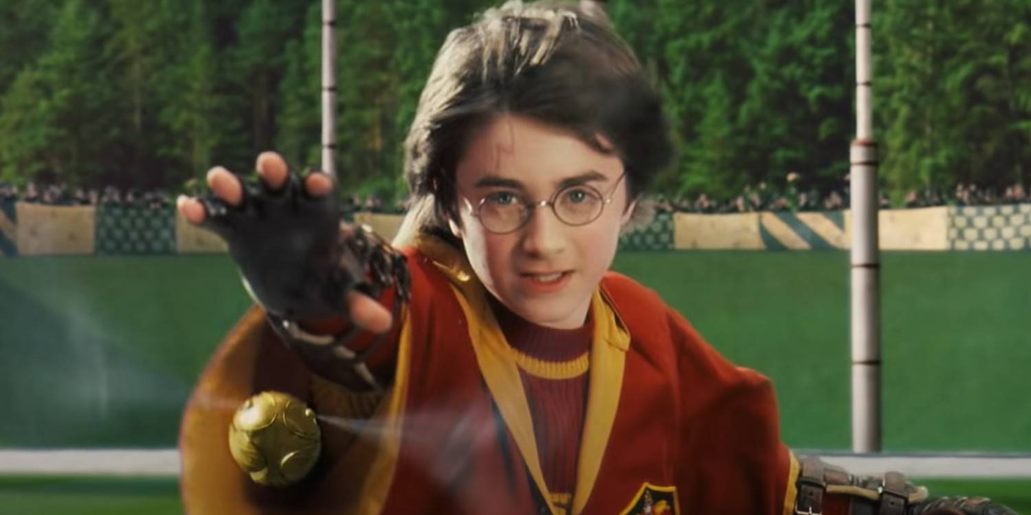 Harry estendendo a mão para o pomo de ouro em Harry Potter e a Pedra Filosofal