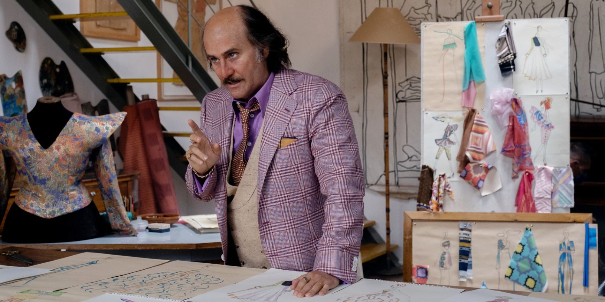 Paolo Gucci stands in front of his design table in House of Gucci.