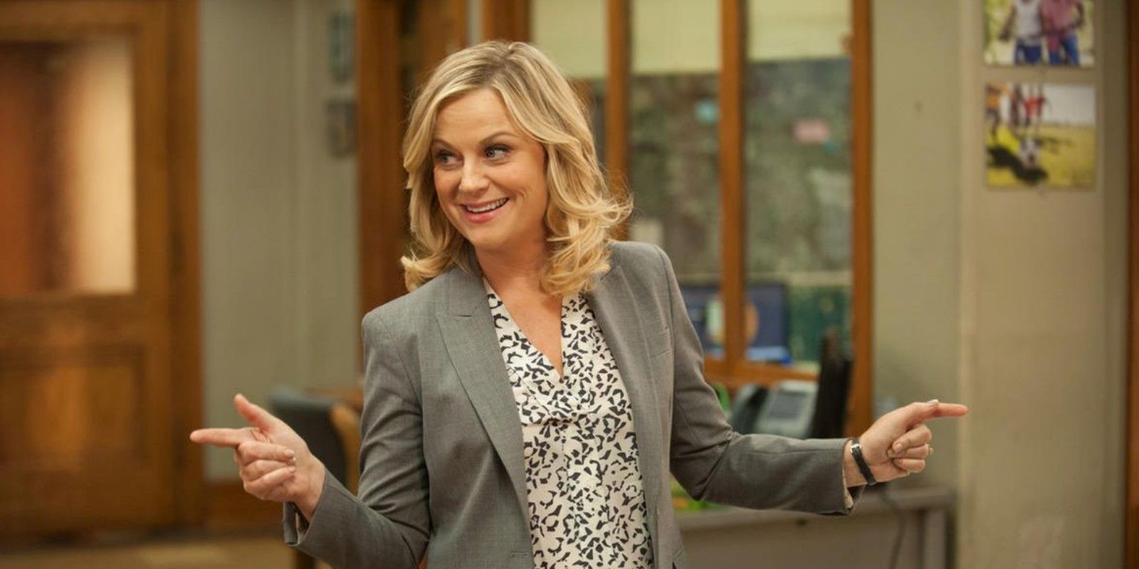 Leslie Knope smiling in the office in Parks and Recreation