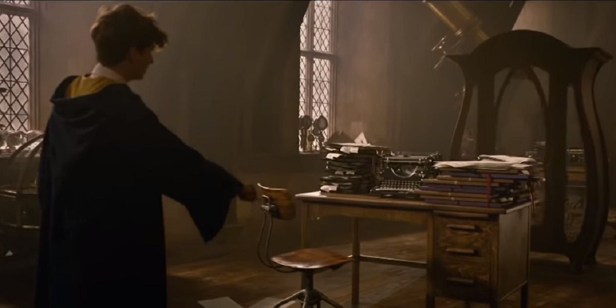 New Scamader looks at a table filled with folders in Fantastic Beasts 2