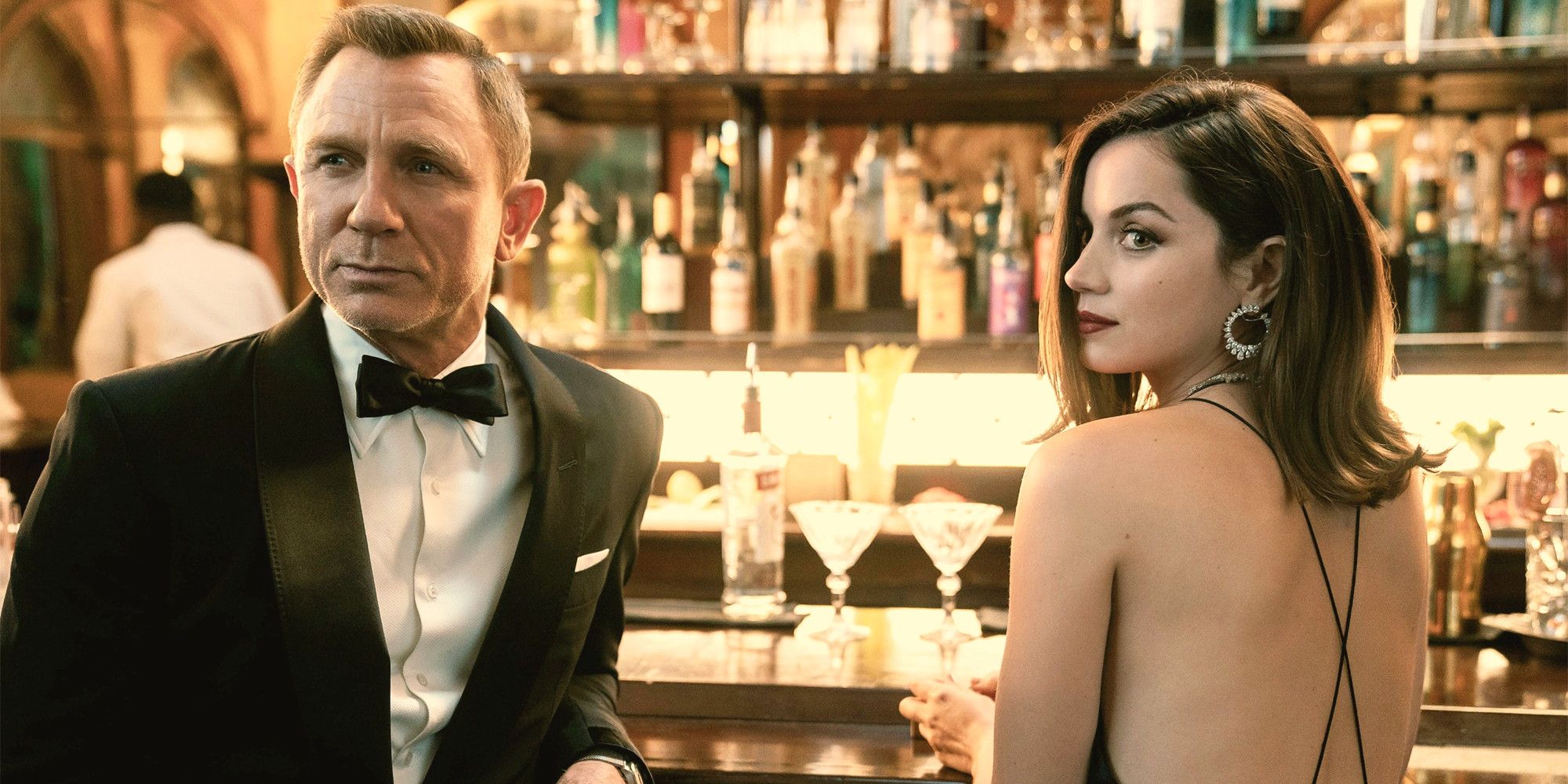 Bond and Paloma at a bar looking in the same direction in No Time To Die 