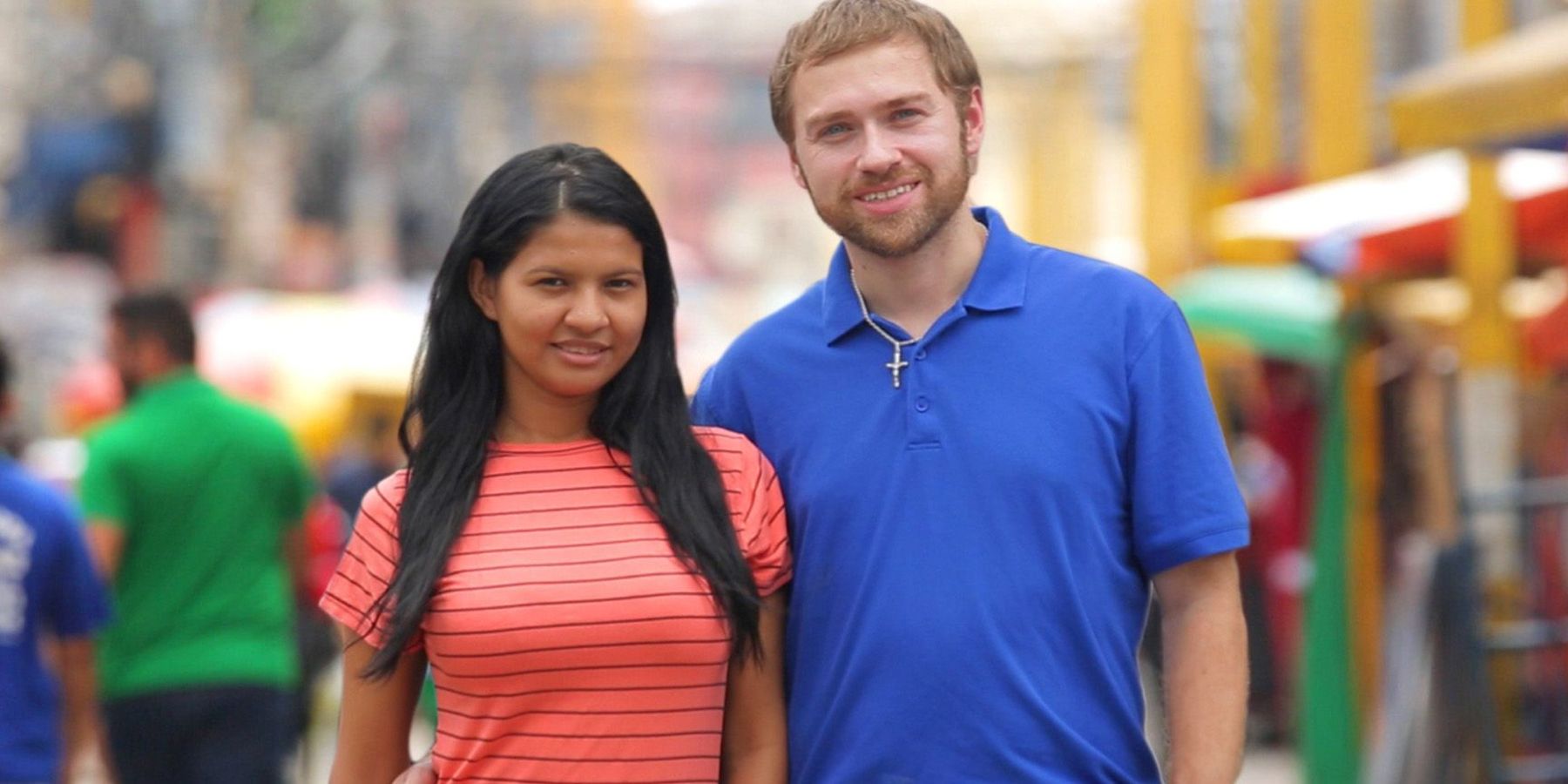 Paul and Karine from TCL's 90 Day Fiancé series smiling and standing on street