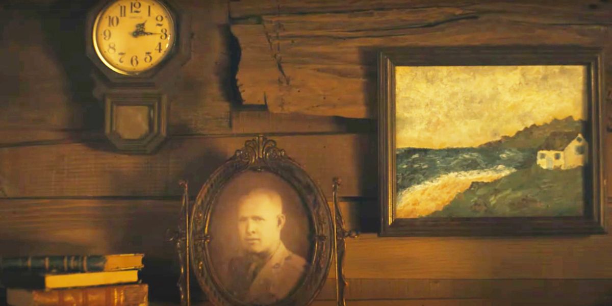 A photo of an older man, a clock, &amp; a painting on a wall in Cardigan.