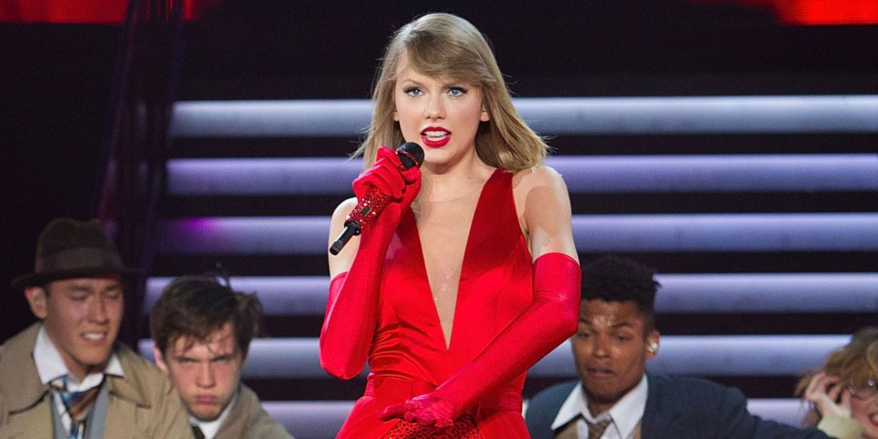 Taylor Swift singing in a red dress.