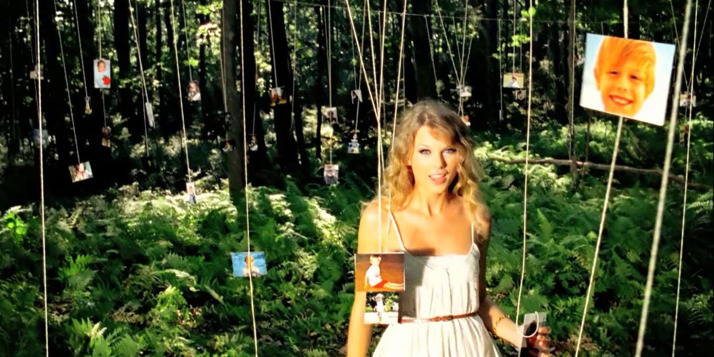 Taylor Swift in a forest surrounded by hanging pictures