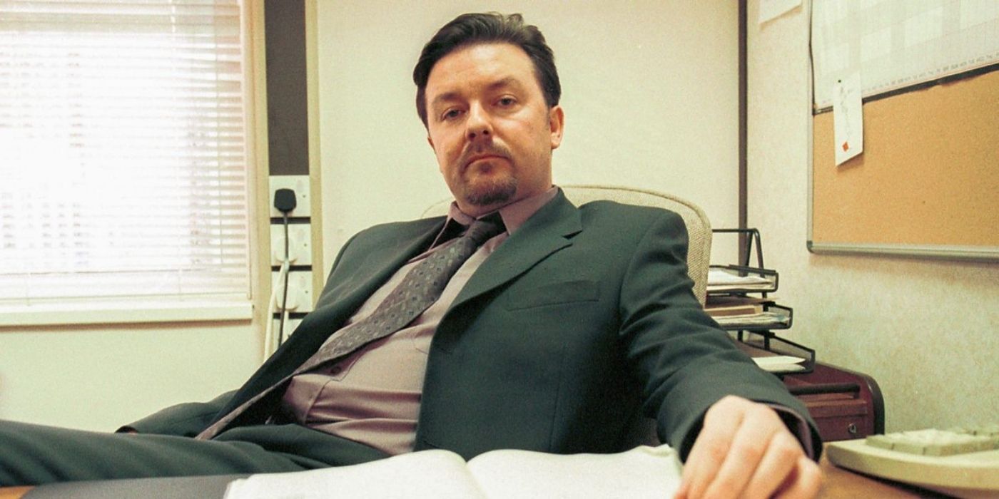 David Brent on his desk looking down at the camera in The Office UK