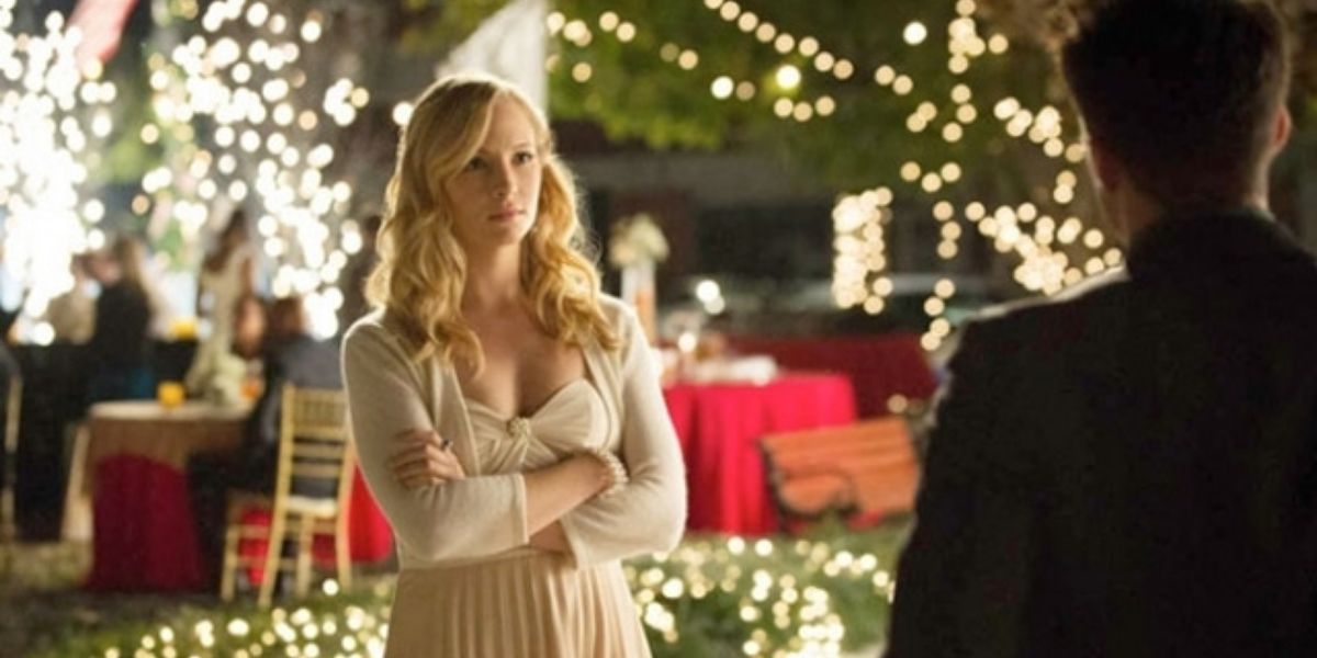 Caroline looking annoyed at someone offscreen at a holiday party in The Vampire Diaries 