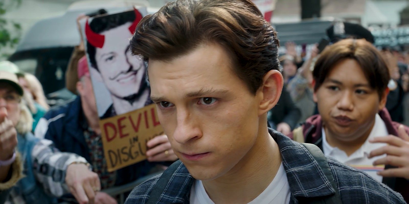 Peter walking through a crowd while looking sad in Spider-Man No Way Home fame