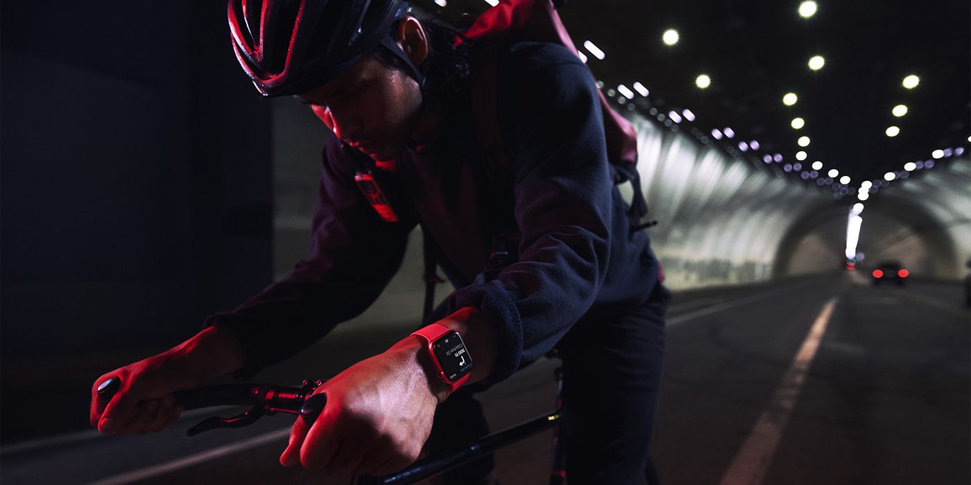 A man cycling in the dark wearing an Apple Watch Series 7.