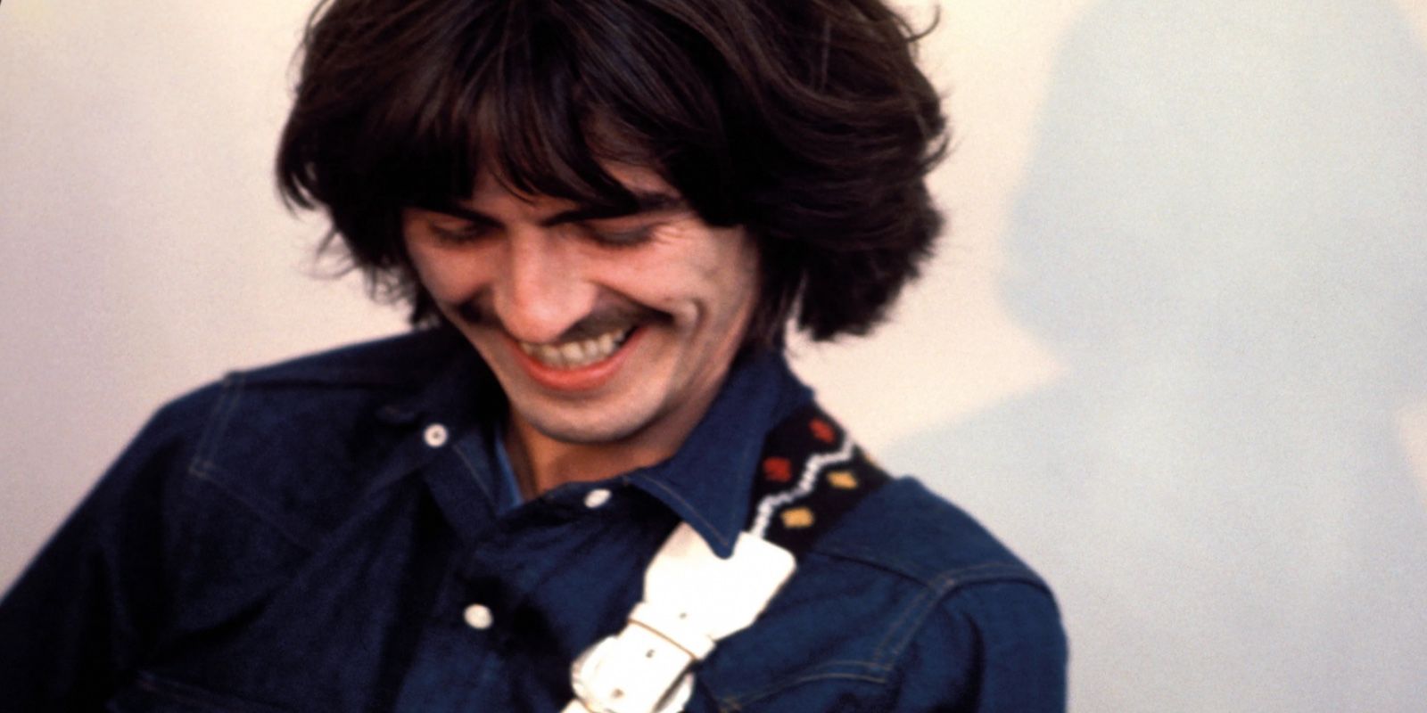 George grins as he plays in The Beatles: Get Back