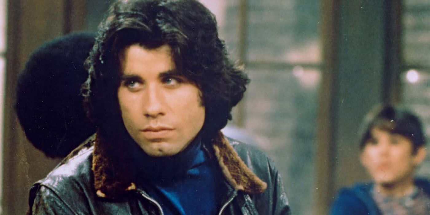 John Travolta with long hair, looking off to the side in a scene from Welcome Back, Kotter.