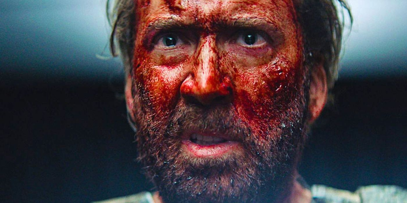 Um Nicolas Cage encharcado de sangue olha com raiva para Mandy