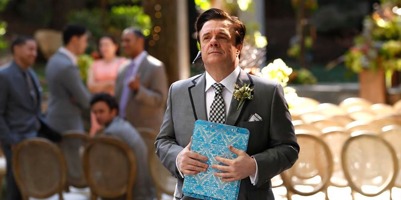 Pepper from Modern Family standing outside at a wedding, holding a planning booklet.