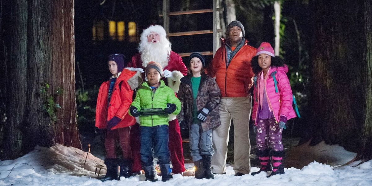 Santa stands with a group of children and one adult in the snow in Santa Hunters.