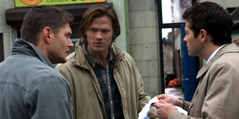 Sam and Dean speak with Castiel indoors on Supernatural