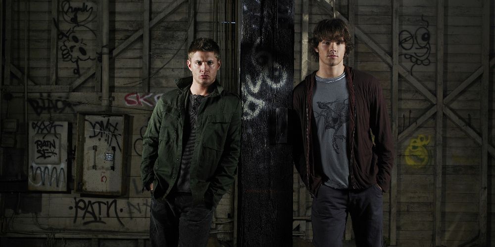 Sam and Dean pose on a post for Supernatural promo image