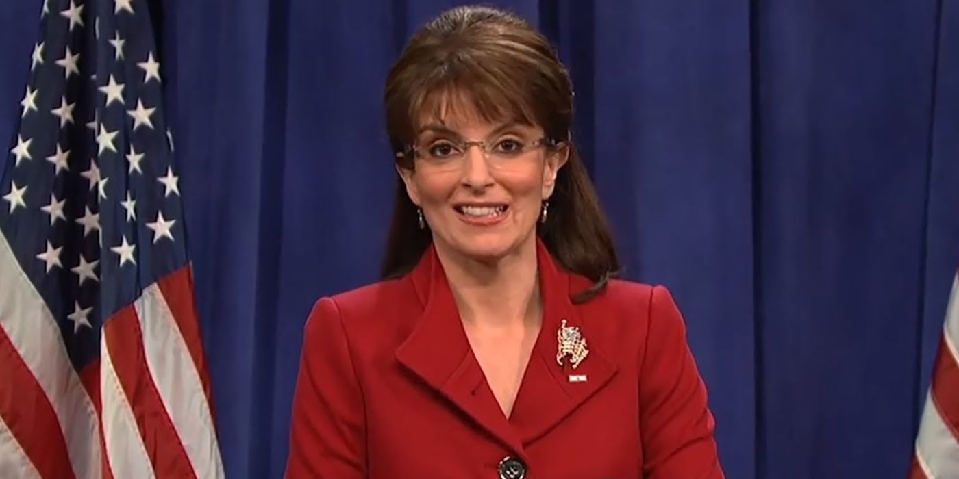Tina Fey como Sarah Palin em um esboço do Saturday Night Live, em pé em um pódio com a bandeira americana atrás dela.