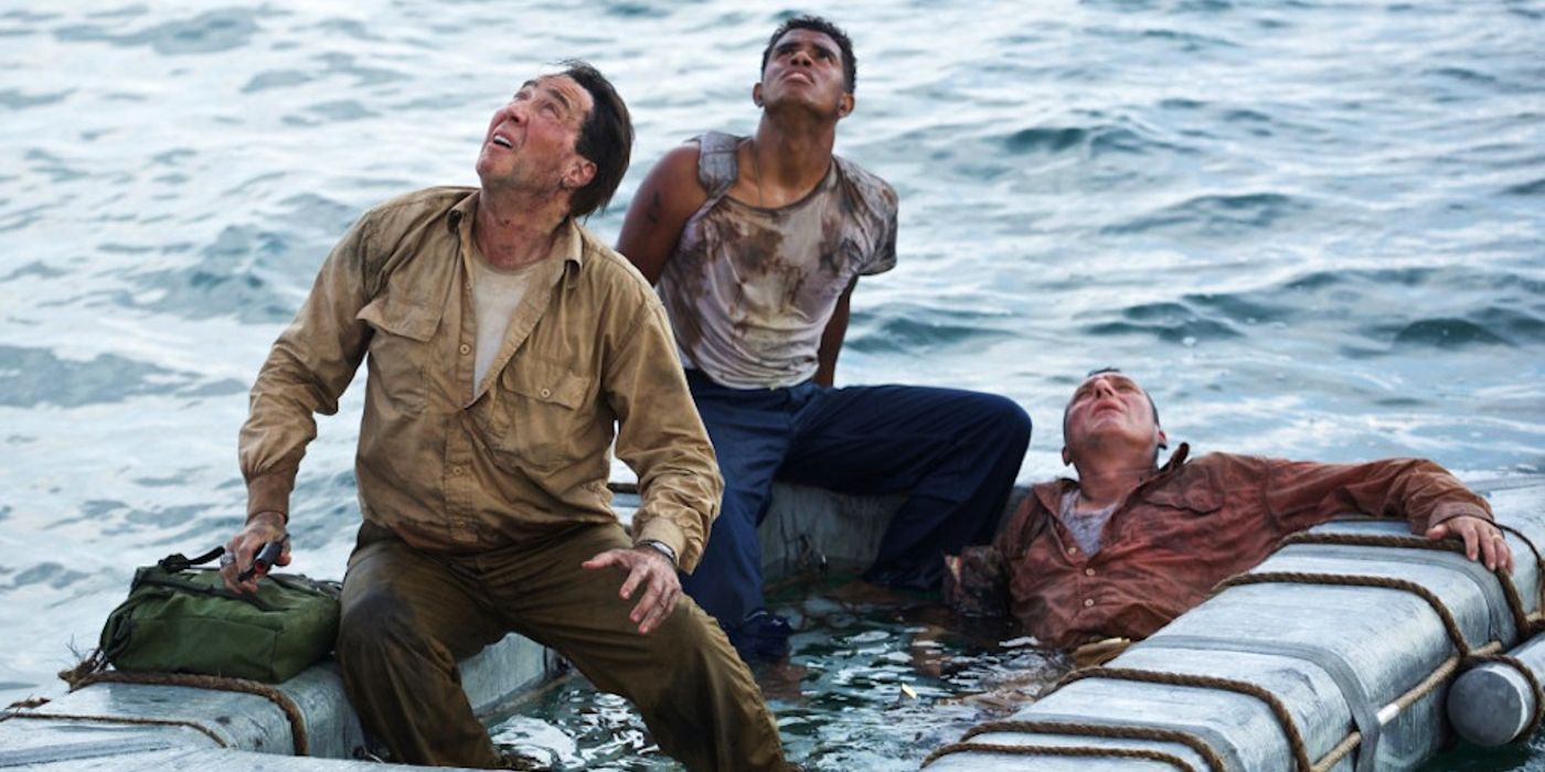 Nicolas Cage sits on a boat and looks up in a still from USS Indianapolis