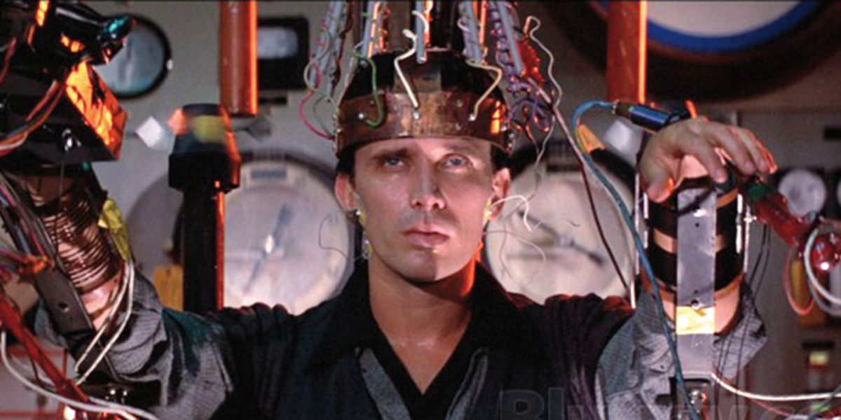Buckaroo sits with a machine on his head in The Adventures Of Buckaroo Banzai Across The 8th Dimension